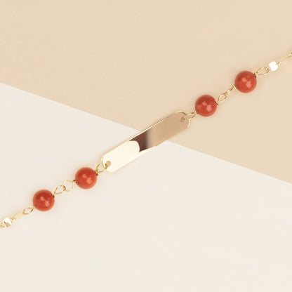 Bracciale baby con corallo rosso e targa oro giallo