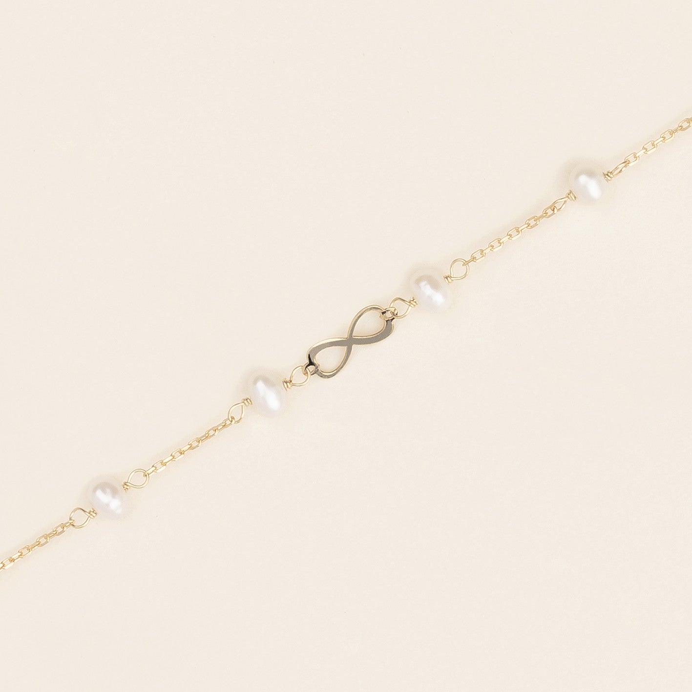 Bracciale baby con perline ed infinito oro giallo